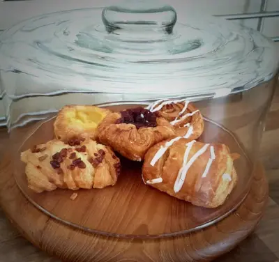 four donuts on a glass plate on a glass table at Castleblair Snug - Entire Flat in Dunfermline in Dunfermline