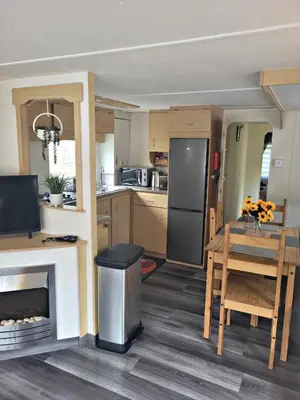 a kitchen with a table and a refrigerator and a dining room at The Rabbit Hill Holiday Home in Ballantrae