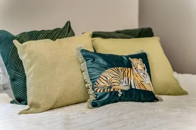 a pillow with a tiger on it sitting on a bed at The Garden Flat, Loch Lomond in Alexandria
