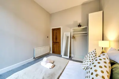 a bedroom with a bed with a teddy bear on it at Stylish & Spacious 3 Bedroom Apt in Finnieston, West End in Glasgow