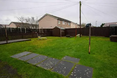 a yard with a fence and a bench in the grass at PREMIER - Chapel House with Driveway! in Cleland