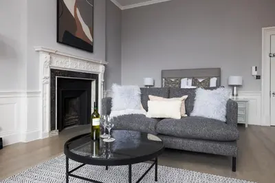 a living room with a couch and a table at JOIVY Modern Studio in New Town, on Historic George Street in Edinburgh