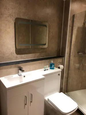 a bathroom with a sink and a toilet and a mirror at Pier Head in Largs
