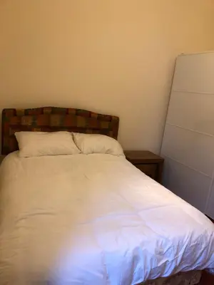 a bedroom with a white bed with a wooden headboard at Pier Head in Largs