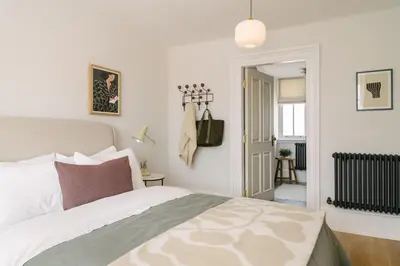 a bedroom with a large bed and a hallway at The Dundonald Guesthouse & Cottage in Culross