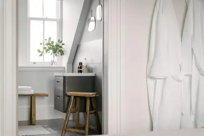a bathroom with a sink and a stool and a window at The Dundonald Guesthouse & Cottage in Culross