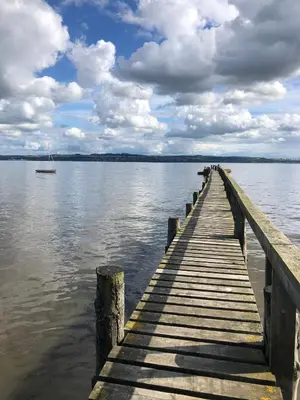 a dock on a body of water with a boat at The Dundonald Guesthouse & Cottage in Culross