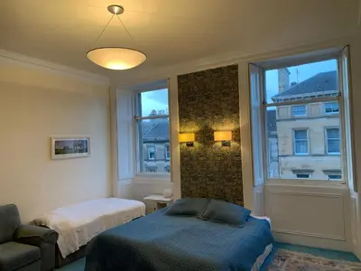 a bedroom with a bed and a window and a bed and a couch at 2 Chester St in Edinburgh