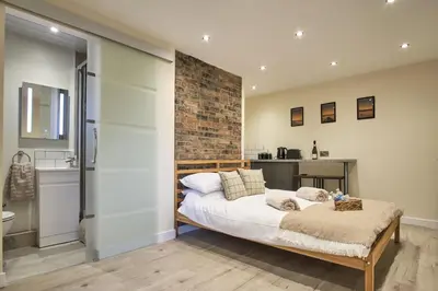 a bedroom with a bed and a brick wall at Seòmar Beag in Oban