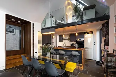 a kitchen with a glass table and some chairs at Roselea Cottage in Luss