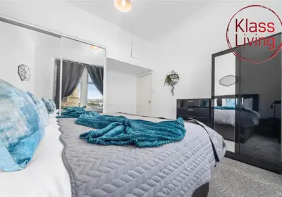 a bedroom with a large bed with a large mirror at Garturk Apartment by Klass Living Coatbridge in Coatbridge