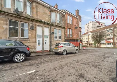 two cars parked next to a building on a street at Garturk Apartment by Klass Living Coatbridge in Coatbridge