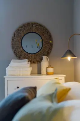 a room with a mirror on a table with a bed at The Trossachs Apartment in Doune