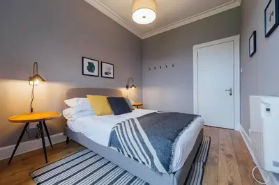 a bedroom with a bed and a table in it at The Trossachs Apartment in Doune