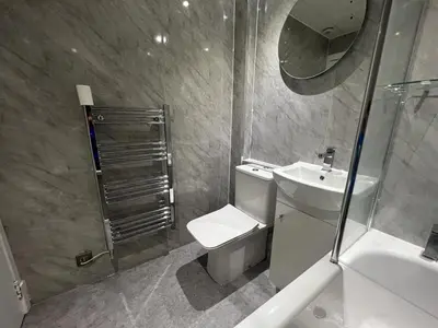 a bathroom with a toilet and a sink and a mirror at The Trossachs Apartment in Doune