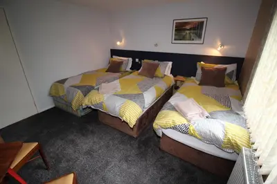two twin beds in a room with at Allandale House in Brodick