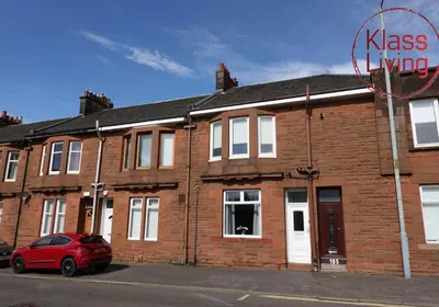 a red car parked in front of a brick building at Mossend Apartment by Klass Living Bellshill in Mossend