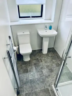 a bathroom with a toilet and a sink and a window at Modern 2 Bedroom Apartment With Free Parking in Glasgow