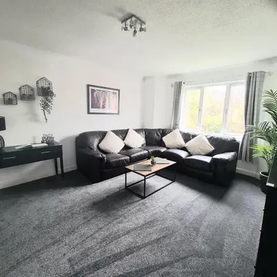 a living room with a couch and a coffee table at Levenside Holiday Apartment, Balloch, Loch Lomond in Balloch