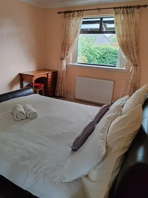 a bedroom with a bed with two pillows and a window at Wallace View - Holiday Home in Stirling
