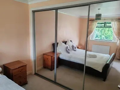 a bedroom with a bed and a mirror at Wallace View - Holiday Home in Stirling