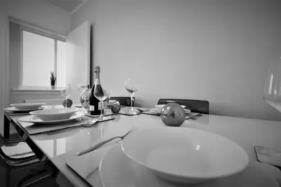 a table with a plate and wine glasses on it at Signature - North View in Cambusnethan