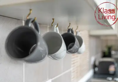 a group of coffee cups hanging on a wall at Berwick Apartment by Klass Living Coatbridge in Coatbridge
