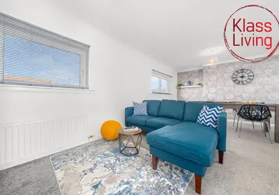 a living room with a blue couch and a table at Berwick Apartment by Klass Living Coatbridge in Coatbridge