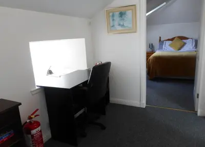 a room with a desk with a bed and a desk at THE COACH HOUSE in Moffat