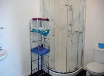 a bathroom with a shower and a rack with towels at THE COACH HOUSE in Moffat