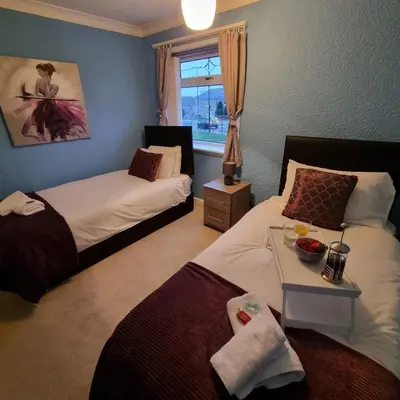 a hotel room with two beds and a window at PREMIER - Whifflet Apartment in Coatbridge