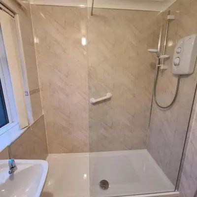 a shower with a glass door next to a sink at PREMIER - Whifflet Apartment in Coatbridge