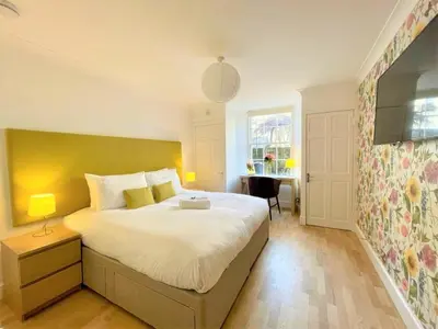 a bedroom with a large bed and a window at Elite 3 Bed New Town Apt with Private Walled Garden in Edinburgh