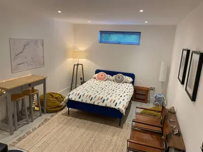 a bedroom with a bed and a desk in it at The Den - your cosy sleepover space in Saint Fillans