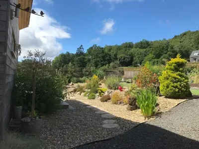 a garden with many different plants and bushes at The Den - your cosy sleepover space in Saint Fillans