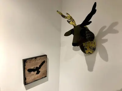 a moose head hanging on a wall next to a picture at The Den - your cosy sleepover space in Saint Fillans
