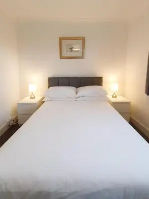 a bedroom with a large white bed with two lamps at 3 bedroom house Amazon M90 Dunfermline Edinburgh in Fife