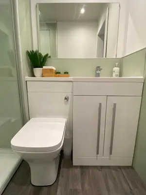 a bathroom with a white toilet and a mirror at Newly refurbished town centre apartment in Oban