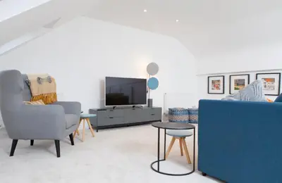 a living room with a blue couch and a tv at Edinburgh Deluxe Duplex with Garage in Edinburgh