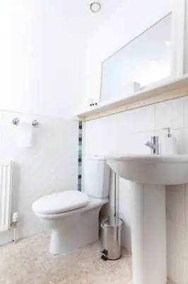 a white bathroom with a toilet and a sink at Edinburgh Deluxe Duplex with Garage in Edinburgh