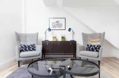 a living room with two chairs and a glass table at Edinburgh Deluxe Duplex with Garage in Edinburgh