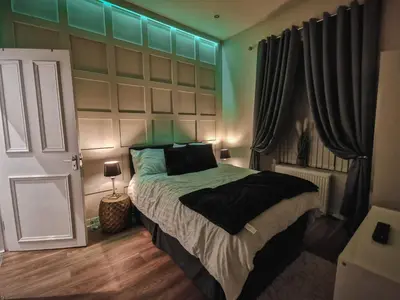 a bedroom with a large bed with a green headboard at 3 bed apartment in the heart of westend of Glasgow in Glasgow
