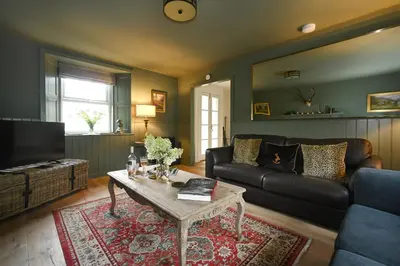 a living room with a couch and a coffee table at Stormont House in Keilour