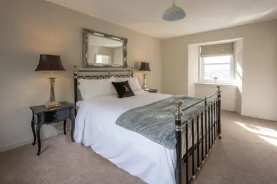 a bedroom with a large bed and a mirror at Stormont House in Keilour
