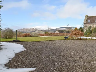 a gravel driveway with a snow covered mountain in the background at White Wisp in Kinross