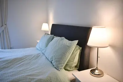 a bedroom with a bed with pillows and a lamp at The Prestwick Pad in Prestwick