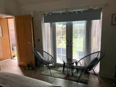 a bedroom with two chairs and a table in front of a window at The Bothy - your unique luxury refuge in Saint Fillans