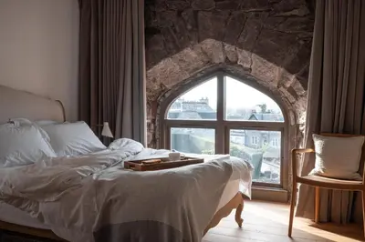 a bedroom with a bed and a large window at The Church Tower in Crieff