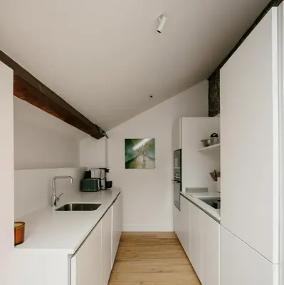 a kitchen with white cabinets and a wooden floor at The Church Tower in Crieff