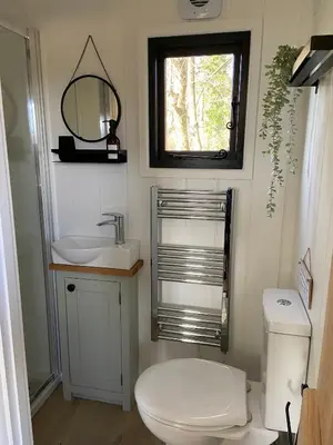 a bathroom with a toilet and a sink and a mirror at Peaceful Shepherd’s Hut in beautiful countryside. in Linlithgow